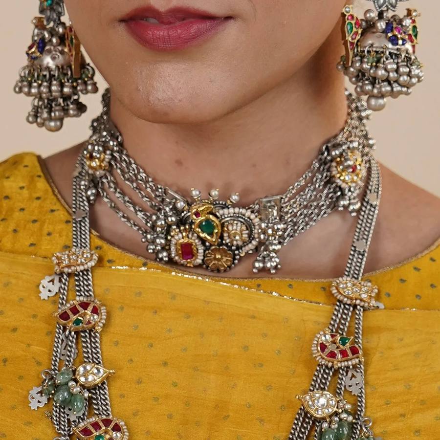 Model wearing layered tribal silver necklaces and jhumka earrings