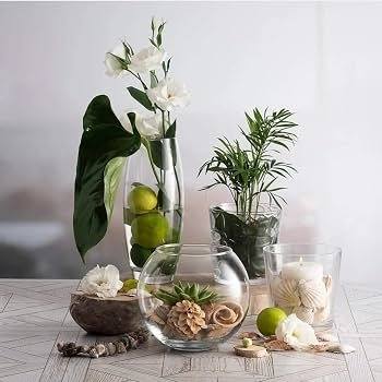 Clear glass vases and bowls with plants and candles