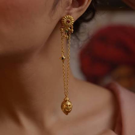 Model wearing gold statement drop earrings