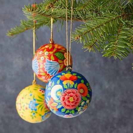 Hand-painted floral papier-mâché baubles on a tree branch