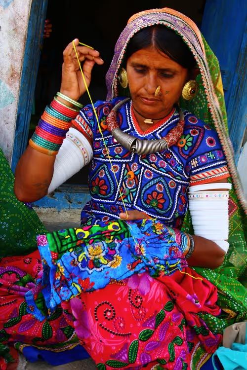 Rabari artisan woman hand-embroidering traditional textile